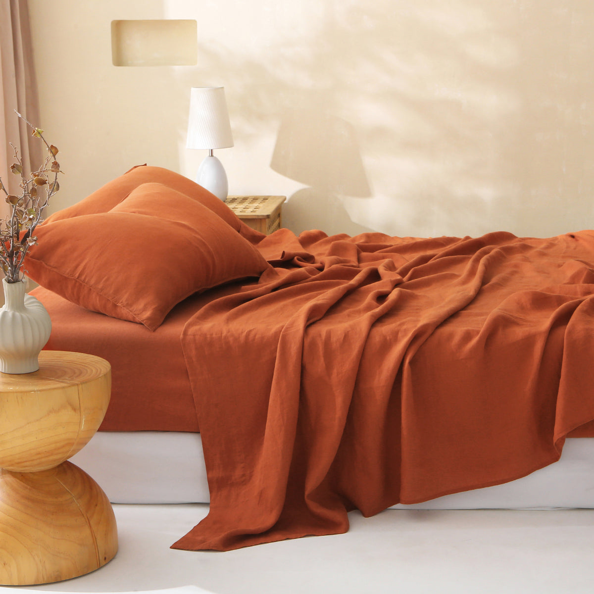Terracotta linen sheet set with natural texture soft natural light on a neutral bedroom bed