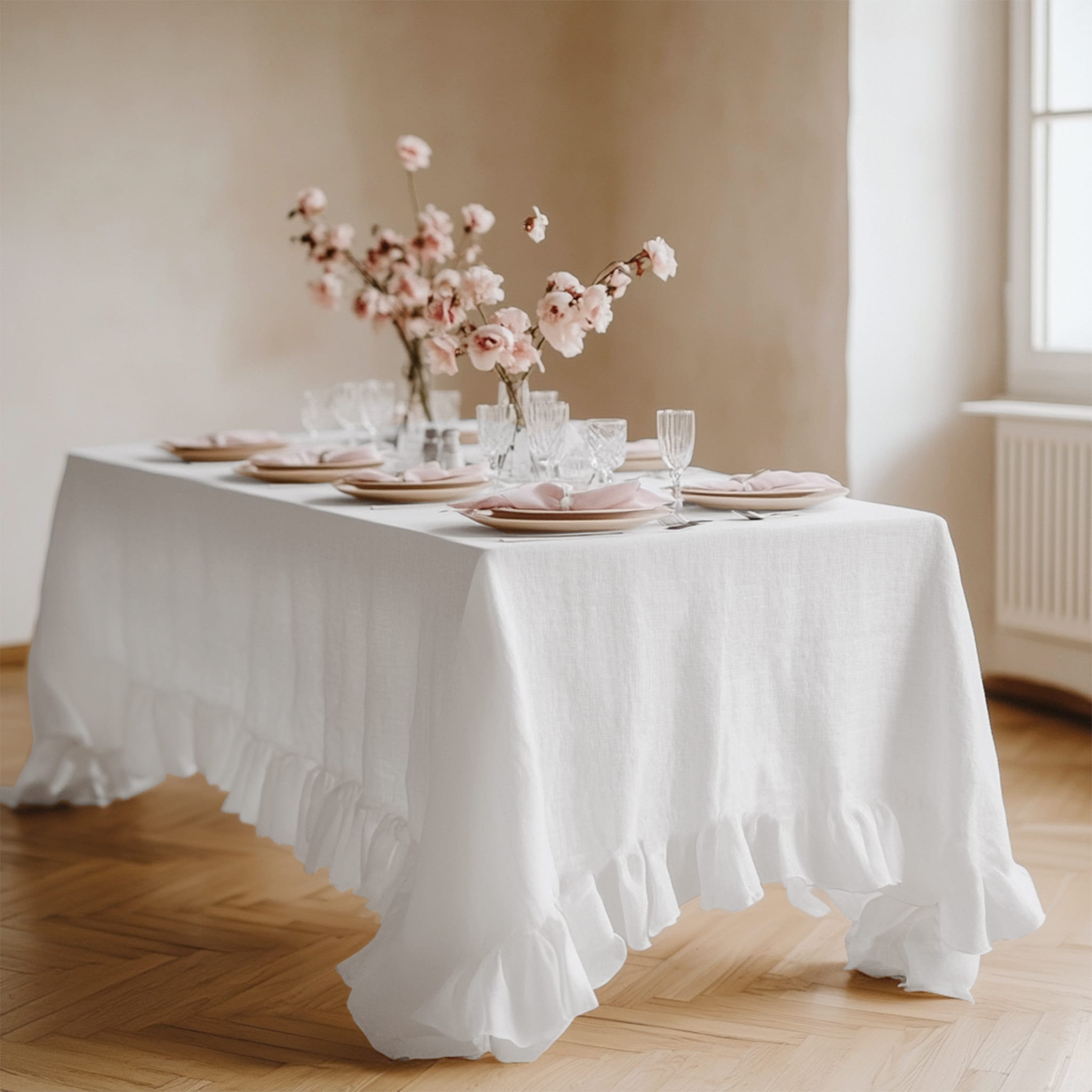 White ruffled linen tablecloth on a rustic dining table with floral decor - Linen Times